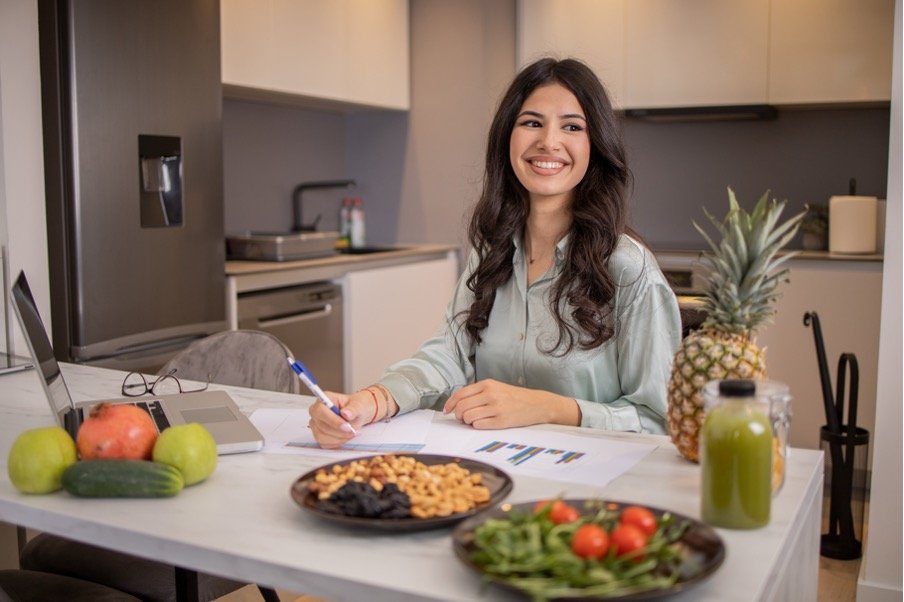 A nutritionist reviewing financial reports at her kitchen table